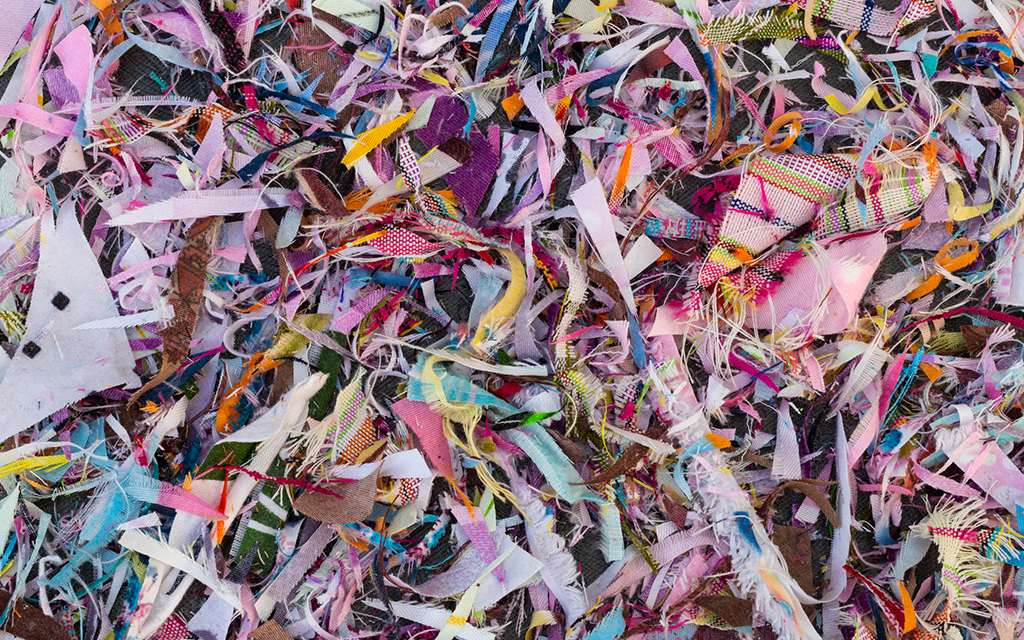 Colorful pile of textile scraps and fabric remnants in various patterns and textures